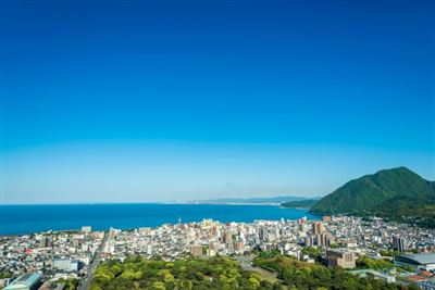 Stadtansicht von Beppu Stadt und Beppu Bucht mit blauem Himmel Hintergrund, Oita, Kyushu, Japan